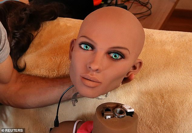 An engineer holds the head of 'Samantha,' a sex doll packed with artificial intelligence. The doll is capable of responding to different scenarios and verbal stimulus